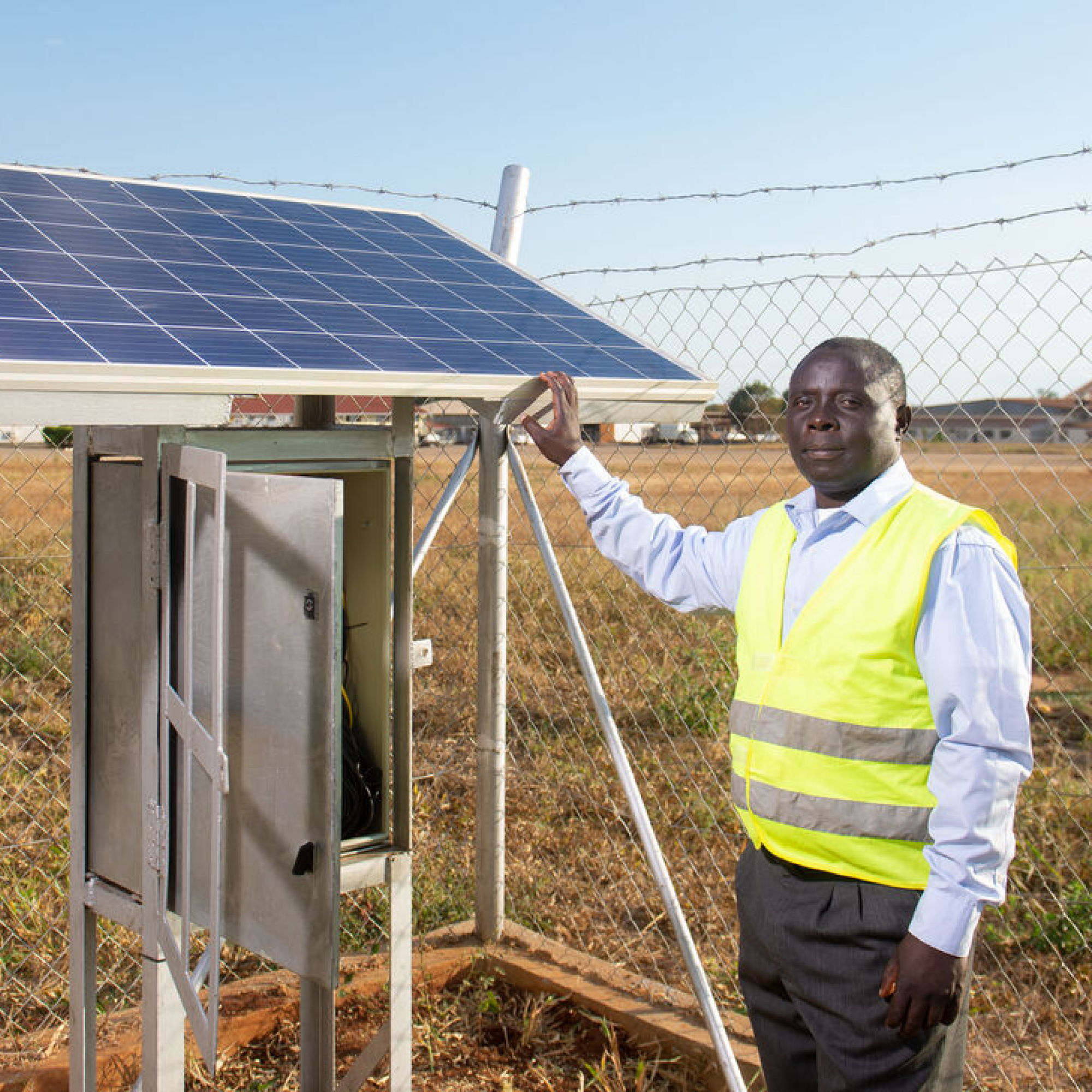 a black man holding a solar panel