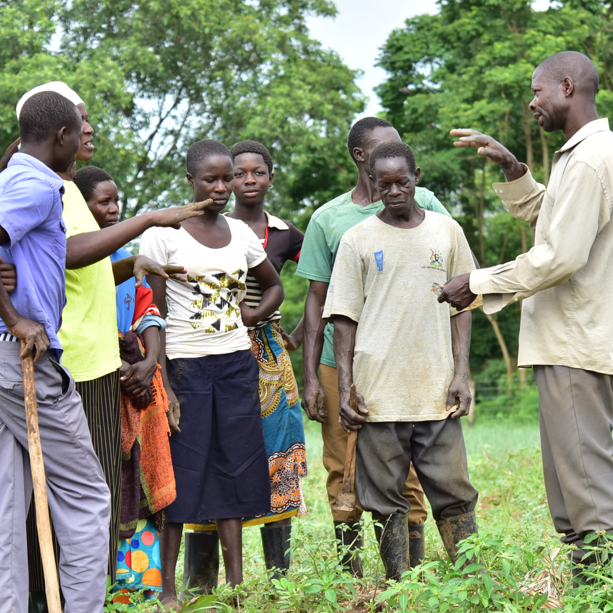 A group of people from Uganda is speaking. Background green trees