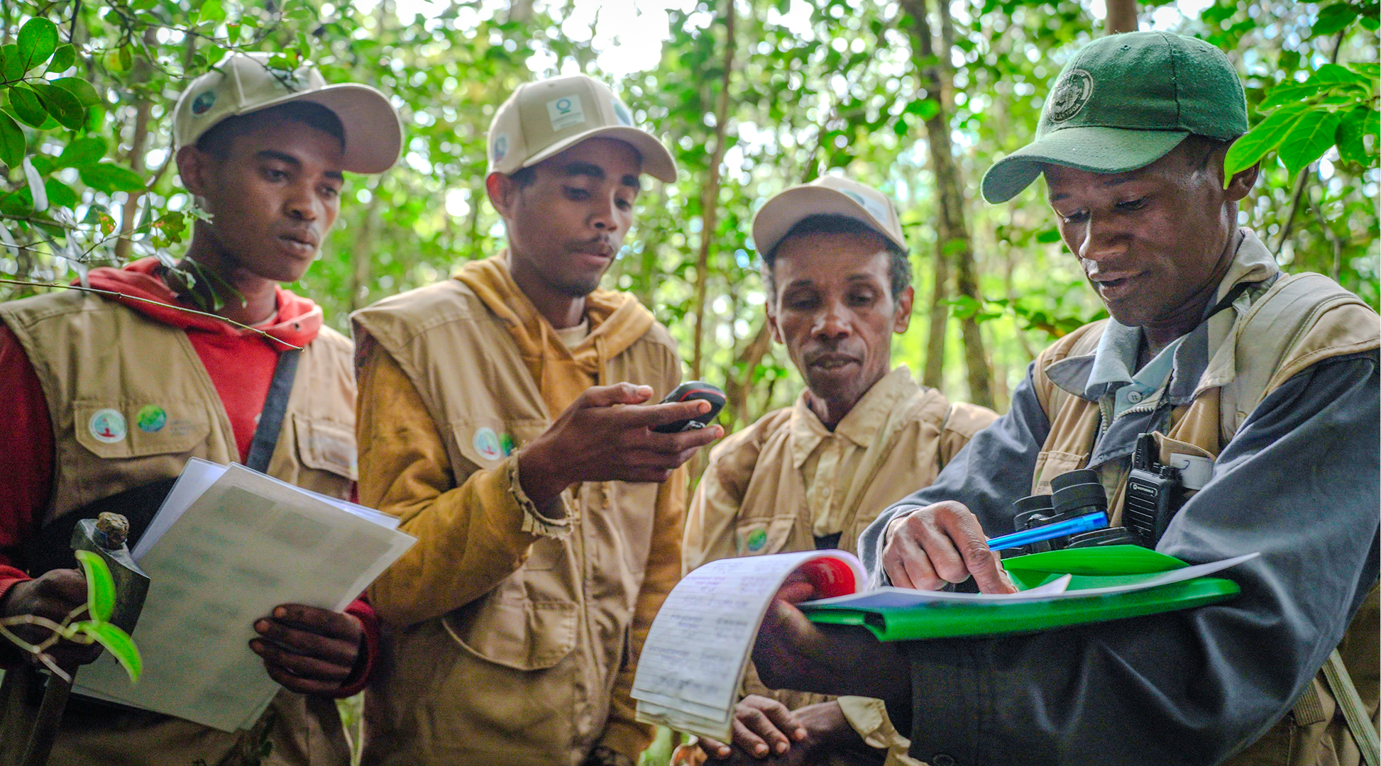  R. Prospere (right) briefs fellow forest patrollers as they inspect Ambositra Vondrozo forest corridor, Madagascar. They are part of a patrolling system in a project supported by GCF — uniting farmers, conservationists, and the national gendarmerie to monitor and protect forests. Photo: GCF / Little Big Films
