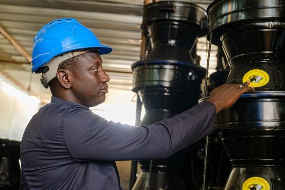 Mbathie Sow, showcasing his stoves, as well as the label for marketing, at his new workshop in Dakar, Senegal.
